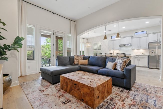 Living room with light wood-style floors, arched walkways, and recessed lighting | Image 6