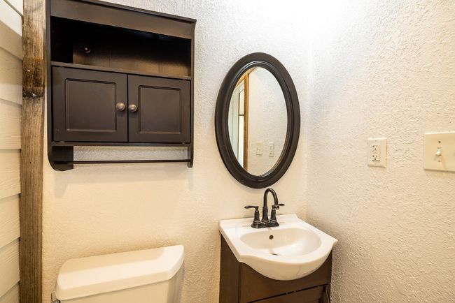 Half bath with toilet, vanity, and a textured wall | Image 24