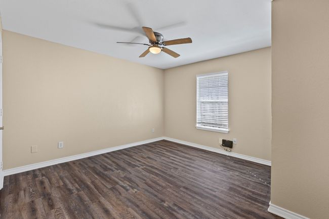 Living room with dark wood-type flooring, a ceiling fan, and baseboards | Image 8