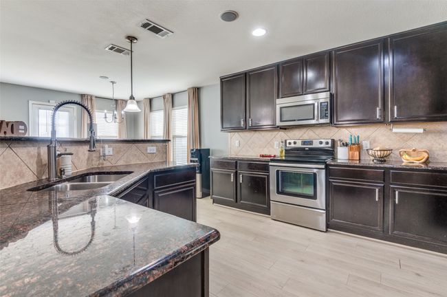 Kitchen with appliances with stainless steel finishes, healthy amount of natural light, backsplash, hanging light fixtures, and recessed lighting | Image 26