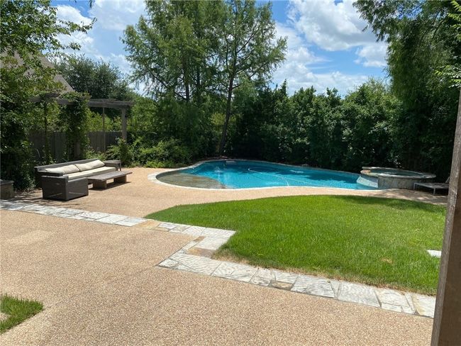 View of pool featuring a patio, a lawn, a pool with connected hot tub, and an outdoor living space | Image 20