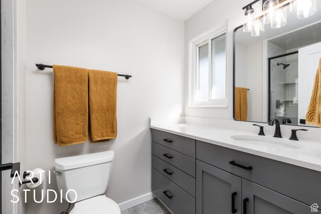 Bathroom with tile patterned floors, an enclosed shower, toilet, vanity, and baseboards | Image 28