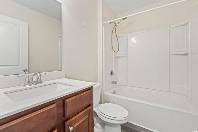 Bathroom with vanity, washtub / shower combination, and wood finished floors | Image 15