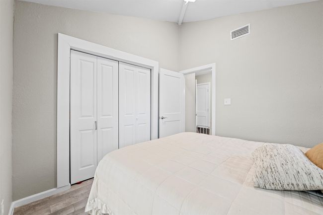 Bedroom with baseboards, wood finished floors, a closet, and visible vents | Image 16