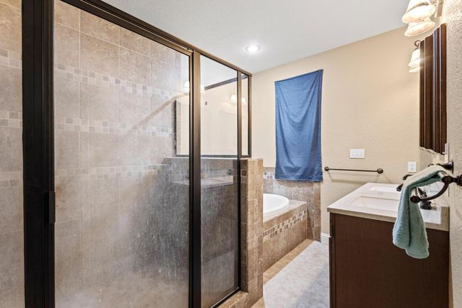 Bathroom with a shower stall, a garden tub, tile patterned floors, and vanity | Image 23