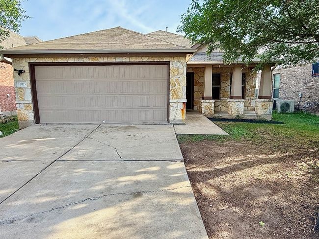 View of front facade with stone siding, concrete driveway, a porch, roof with shingles, and a garage | Image 23