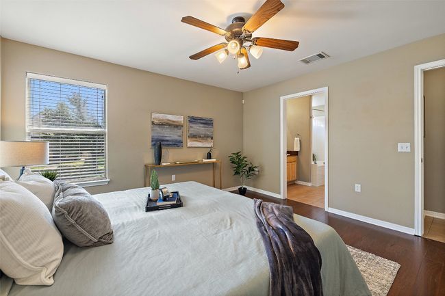 Bedroom featuring wood finished floors, baseboards, ensuite bath, and ceiling fan | Image 19