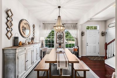 Dining space with dark hardwood / wood-style flooring and an inviting chandelier | Image 3