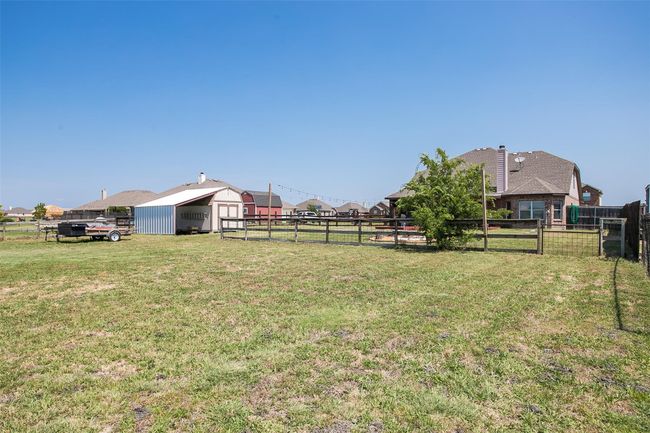 View of yard & storage building with carport. | Image 29