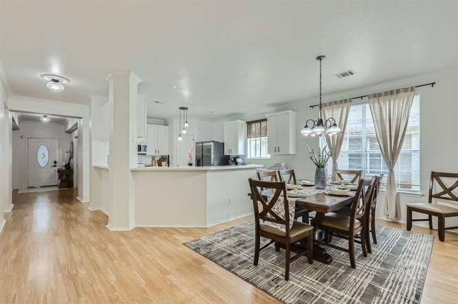 Dining room with light wood-style floors and a chandelier | Image 10