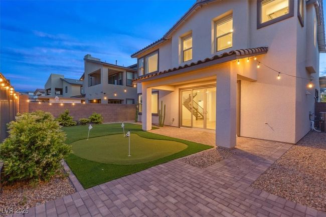 Back of property featuring fence, stucco siding, a tiled roof, and a patio area | Image 4