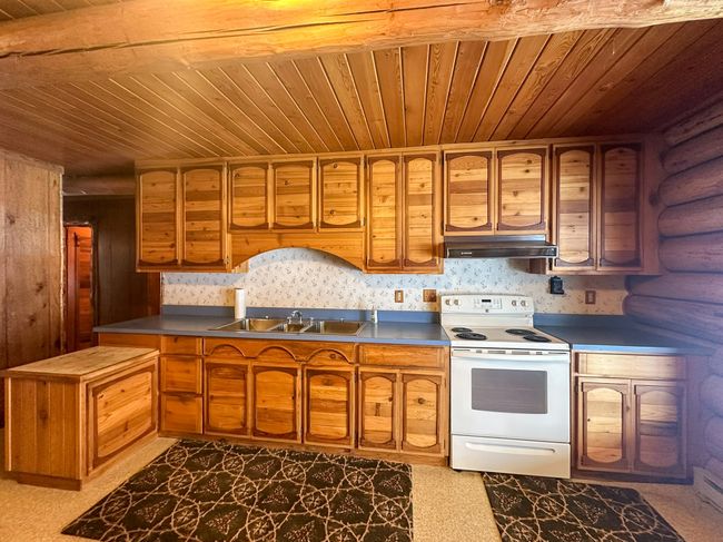 Kitchen featuring sink, wooden ceiling, and white range with electric cooktop | Image 24