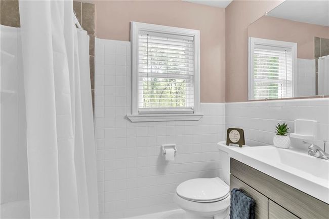 Full bathroom with a shower with shower curtain, plenty of natural light, toilet, and tile walls | Image 32