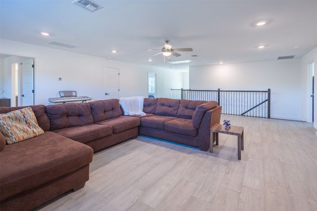 Kick back and relax in the huge upstairs den that features a ceiling fan and recessed lighting. | Image 23