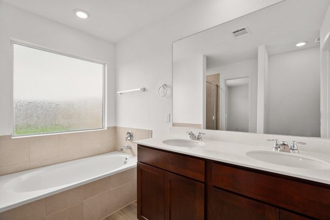 Full bath featuring a garden tub, double vanity, and a shower with shower door | Image 16
