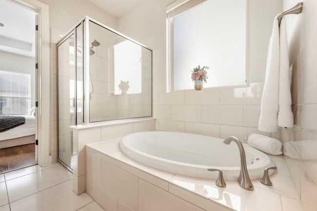 Ensuite bathroom featuring a bath, a shower stall, and tile patterned flooring | Image 16