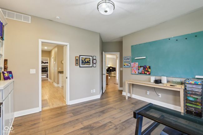 office with baseboards, visible vents, and wood-type flooring | Image 25