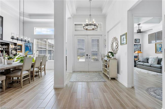 Entryway with baseboards, wood finish floors, ornamental molding, french doors, and a high ceiling | Image 30
