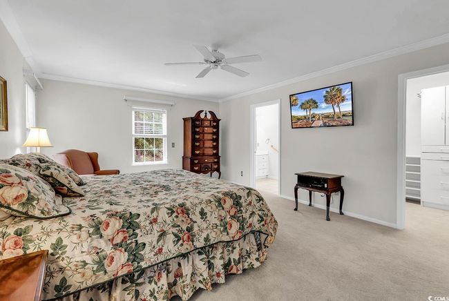 Bedroom with crown molding, light carpet, a ceiling fan, and connected bathroom | Image 10
