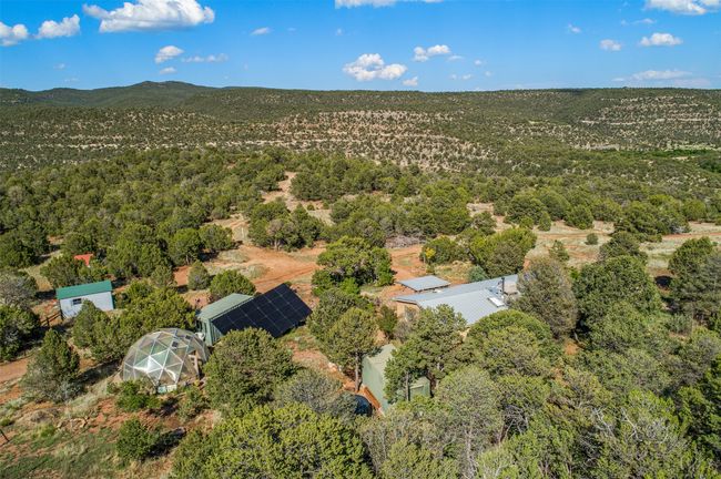 Drone photo from rear of house, with Pecos Wildnerness in background (Cow Creek between property and Pecos Wilderness) | Image 51