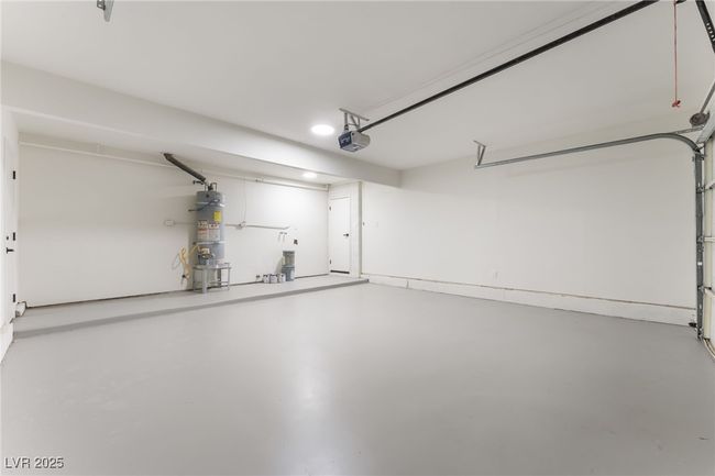 Garage featuring water heater, a garage door opener, and recessed lighting | Image 50