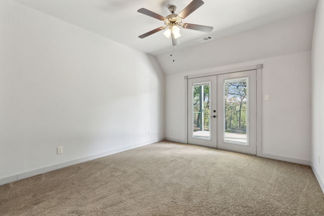 Spare room featuring french doors, ceiling fan, carpet, and vaulted ceiling | Image 30