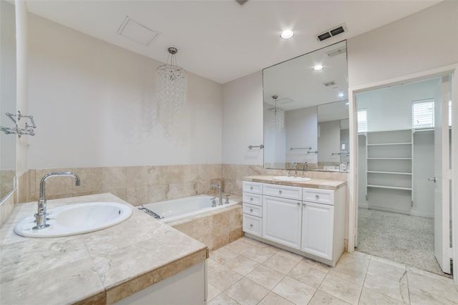 Full bath featuring visible vents, a sink, a bath, and two vanities | Image 9