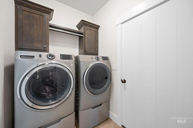 Laundry area featuring washing machine and clothes dryer and cabinet space | Image 20