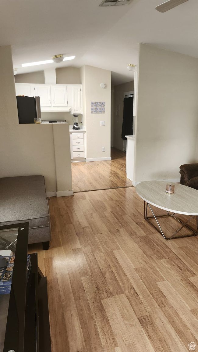Living area with lofted ceiling, light wood finished floors, and baseboards | Image 11