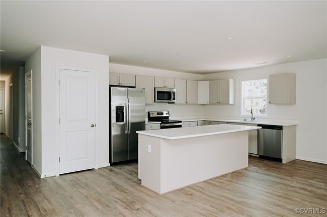 Kitchen with appliances with stainless steel finishes, light hardwood / wood-style flooring, and a kitchen island | Image 5