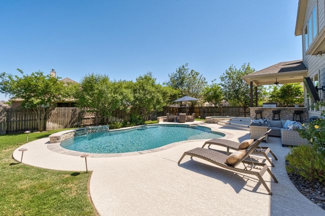 View of swimming pool featuring an outdoor living space, a patio area, a fenced backyard, a fenced in pool, and exterior kitchen | Image 37