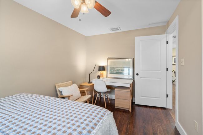 Bedroom featuring dark wood-style flooring, baseboards, ceiling fan, and visible vents | Image 22