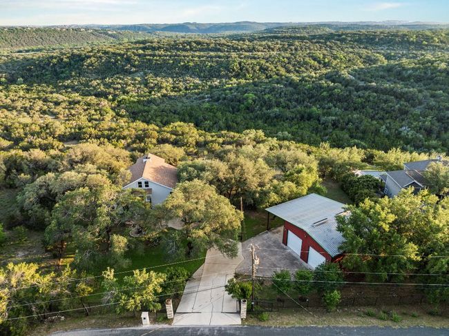 View of long driveway leading to the house on the left and the garage on the right. | Image 31