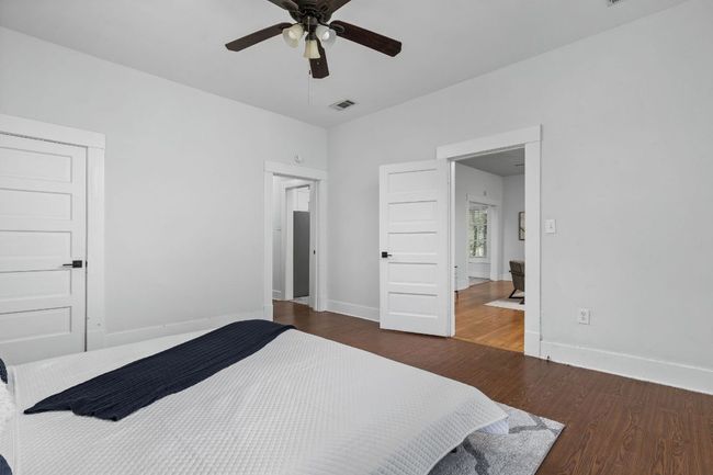 Bedroom featuring wood finished floors, ceiling fan, baseboards, and visible vents | Image 15