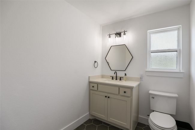 Half bath with vanity, toilet, tile patterned flooring, and baseboards | Image 29