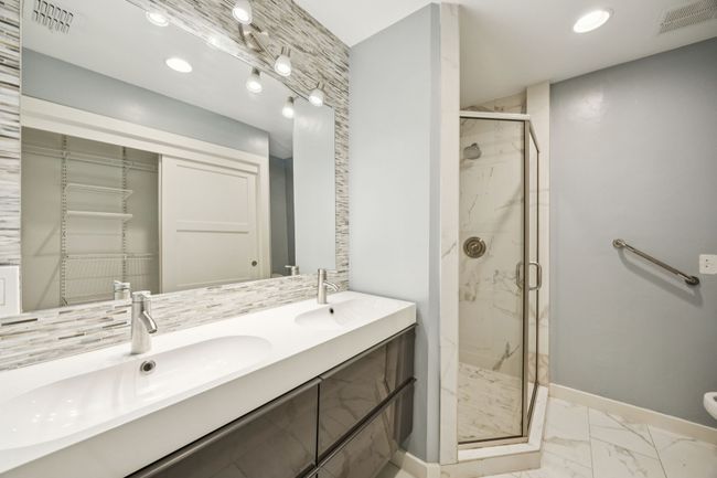PRIMARY Ensuite Features Large Vanity With Storage, Expansive Mirror, Double Sinks, Designer Tile Backsplash, Separate Walk-In Tile Surround Shower, Framed Glass Shower Enclosure, Tile Flooring and Accent Lighting | Image 9
