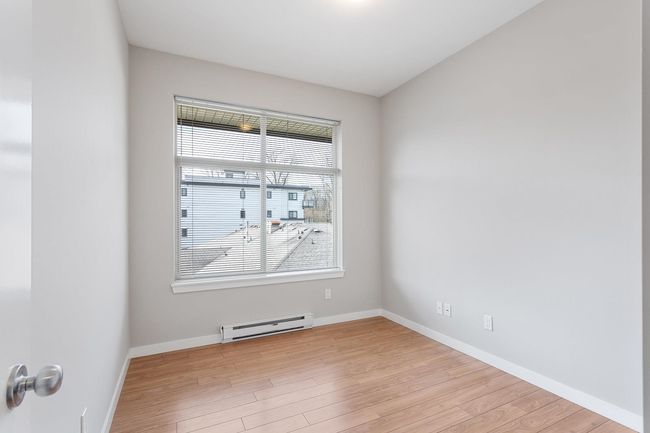 Spare room featuring light wood-style flooring, baseboards, and a baseboard heating unit | Image 23