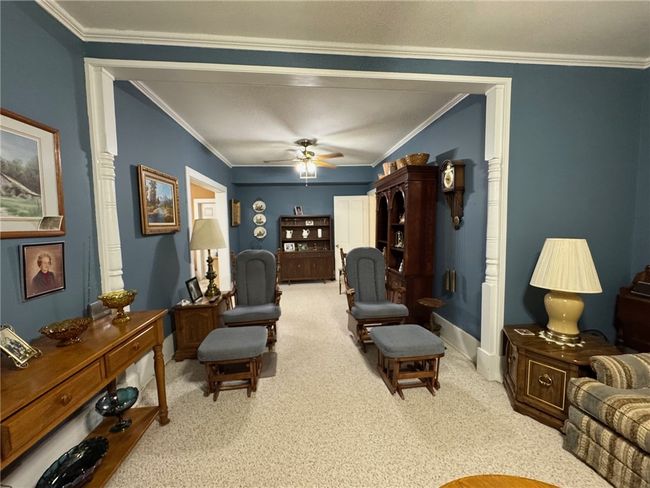 Carpeted living area with crown molding and a ceiling fan | Image 9