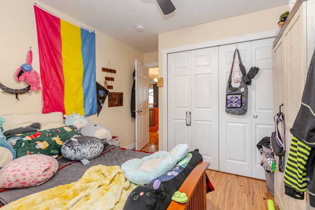 Bedroom with a closet, wood finished floors, and a ceiling fan | Image 15
