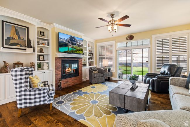 Living room featuring dark hardwood / wood-style floors, built in features, ceiling fan, and ornamental molding | Image 22