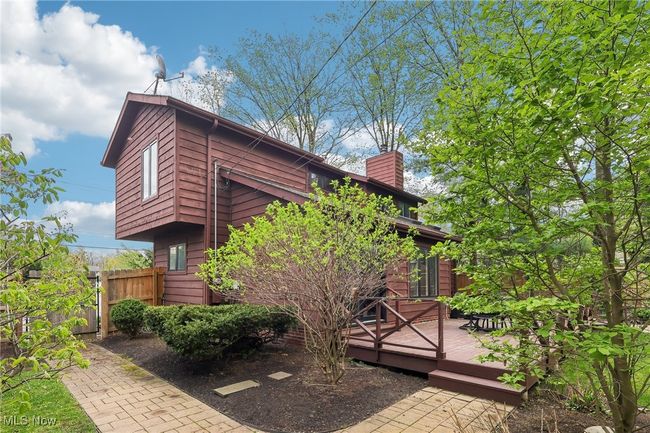 View of home's exterior featuring fence, a deck, and a chimney | Image 33