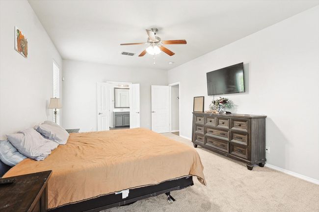 Bedroom with light carpet, ensuite bath, and a ceiling fan | Image 16