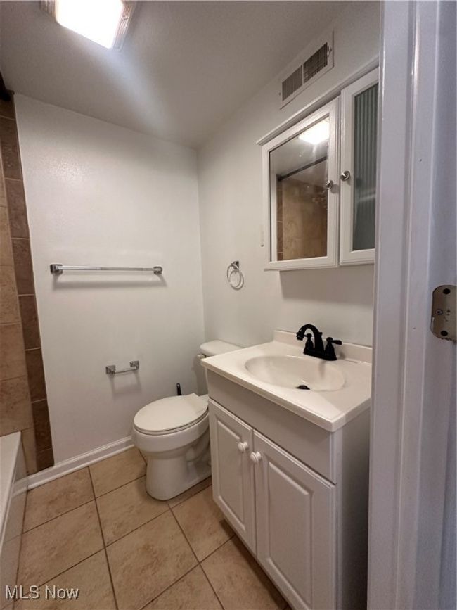 Full bathroom with vanity, toilet, visible vents, walk in shower, and tile patterned flooring | Image 37