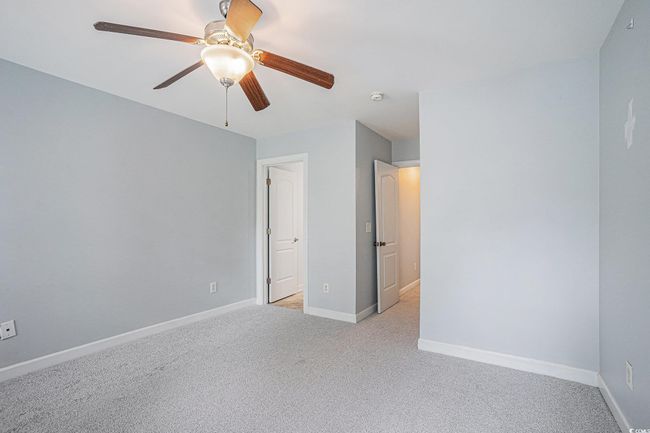 Unfurnished bedroom featuring light carpet and a ceiling fan | Image 11