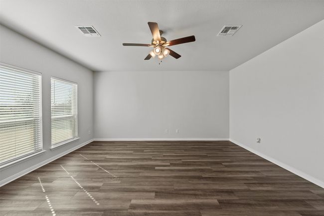 Empty room featuring ceiling fan and wood-look tile floors | Image 8
