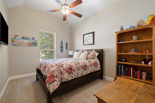 Spacious secondary bedroom situated away from primary bedroom with a vaulted ceiling, walk in closet & light carpet | Image 34