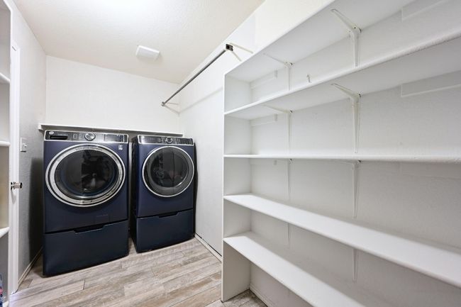 Laundry area with washing machine and clothes dryer and wood finished floors | Image 19
