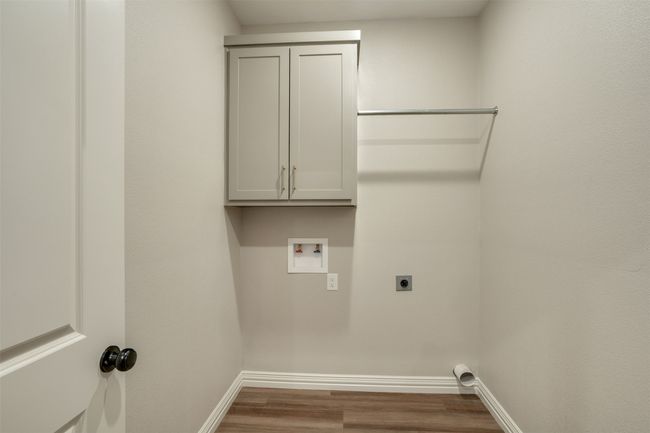 Clothes washing area featuring baseboards, washer hookup, wood finished floors, cabinet space, and electric dryer hookup | Image 25