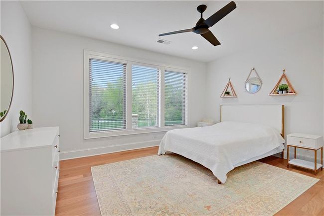 Bedroom featuring baseboards, light wood-style flooring, visible vents, and recessed lighting | Image 54