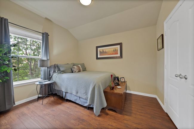 Bedroom featuring baseboards, vaulted ceiling, and wood finished floors | Image 40